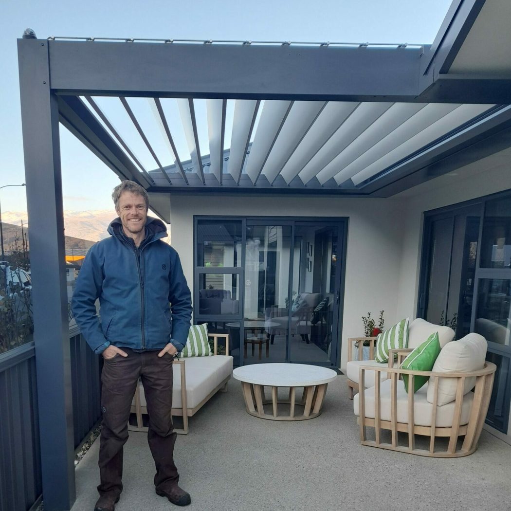 Craig Baker stands in front of NZ Louvres Louvre roof in Queenstown